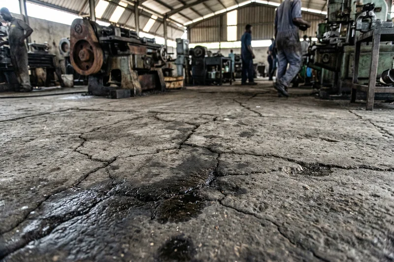 Before: cracked, dusty concrete floor in a Tema factory before premium epoxy installation